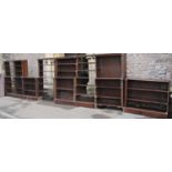 A run of antique oak library bookcases with open fixed shelves, flanked by mock fluted columns and