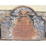 A heavy cast iron fire back of rectangular stepped arched form with raised relief armorial shield