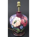 A Moorcroft lamp base with pansy decoration on a burgundy coloured ground, 19cm approx (excluding