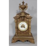 A substantial Victorian mantel clock in a cast brass case detailing mask, scroll and repeating