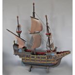 A wooden model of a 15th century galleon in full sail raised on a stand, 60 cm x 70 cm including
