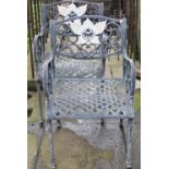 A pair of cast alloy garden chairs with pierced lattice pattern seats, open scrolled arms and