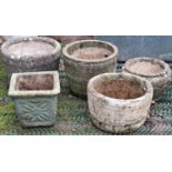 Three weathered cast composition stone garden planters in the form of coopered tubs together with