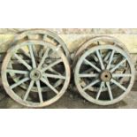 Two pairs of green stained wooden spoked cart/wagon wheels with iron rims, 50 and 56 cm in diameter