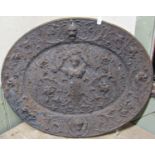 An oval cast iron plaque with raised relief lions mask, scrolling acanthus, dragon, classical figure