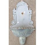 A cast iron wall fountain with fluted reservoir and scrolled detail, 44 cm wide x 75 cm high