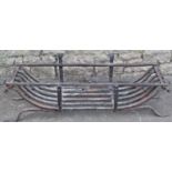 A wrought iron fire basket of rectangular cradle form raised on swept feet, 102 cm wide x 33 cm deep