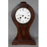 An inlaid Edwardian mahogany mantel clock in a balloon shaped case with convex enamelled dial and