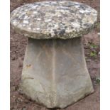 A small weathered cast composition stone staddle stone of square tapered form beneath a domed cap,