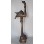 A Chinese cast bronze study of a stork/crane with removable wings and standing on a naturalistic