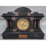 A mid-Victorian period black slate and polished marble mantel clock of architectural form, with