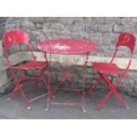 A three piece folding steel bistro set with pierced flower head detail and painted finish
