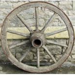 An old weathered wooden cart wheel with ten chamfered spokes, iron rim and hub, 90 cm in diameter