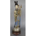 A figurine of a Japanese courtier with an enamelled cloisonné effect finish raised on a wooden