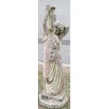 A weathered cast composition stone garden ornament in the form of a classical maiden water carrier