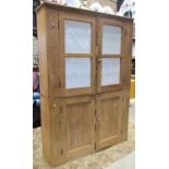 An old reclaimed stripped pine two sectional floorstanding kitchen side cupboard enclosed by two