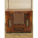 A vintage "His Masters Voice" walnut cased mains radio with Bakelite handles
