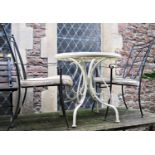 A cream painted light metal garden terrace table of circular form with decorative pierced