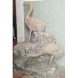 A good quality unusual and weathered garden ornament/study of two cranes in naturalistic setting,