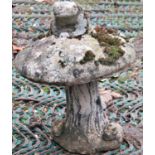 A small weathered two sectional composition stone garden ornament in the form of a toad stool with