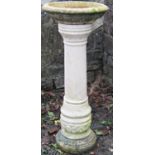 A weathered two sectional cast composition stone bird bath, the cylindrical canon barrel shaped