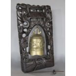 A Chinese carved hardwood gong stand with carved detail to the uprights, fine silver metal