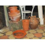 A small quantity of terracotta flower pots, square tapered planter and three handled jar