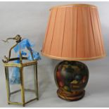 A hand painted table lamp with fruit and vine decoration with a shade, and a hexagonal brass
