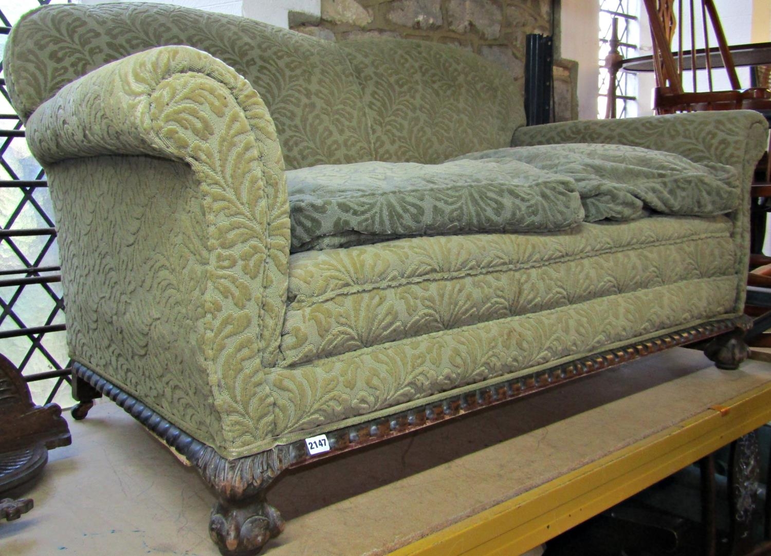 An Edwardian two seat sofa with swept and rolled arms and green coloured cut floral Mouquet