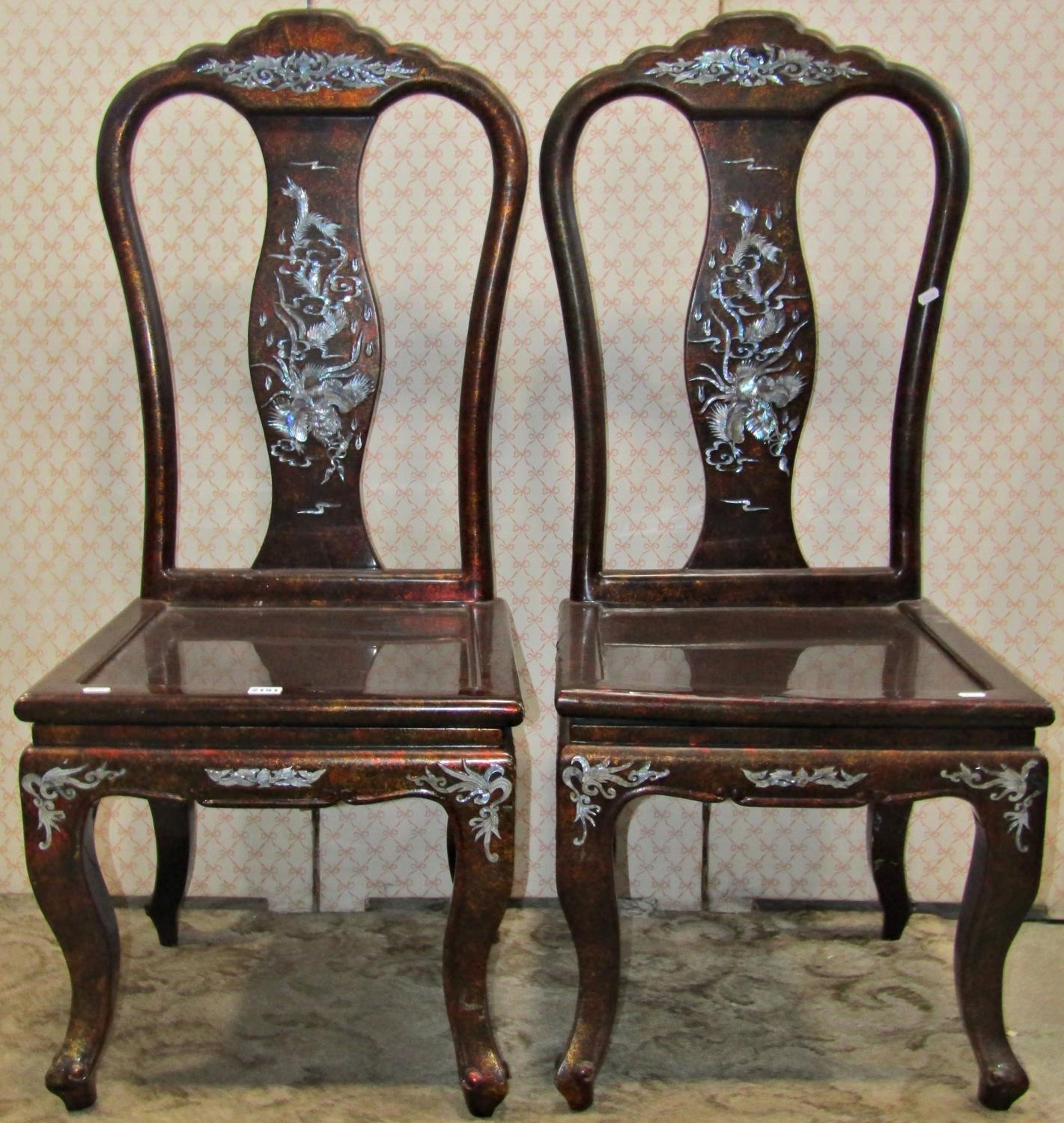 A pair of Chinese hardwood chairs with lacquered finish vase shaped splats and inlaid mother-of-