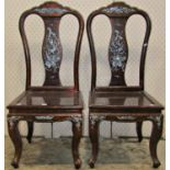 A pair of Chinese hardwood chairs with lacquered finish vase shaped splats and inlaid mother-of-