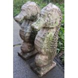 A pair of novelty weathered cast composition stone garden ornaments/pier caps in the form of sea