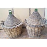 A pair of 19th century wicker clad green glass wine carriers, straw insulated, 70 cm