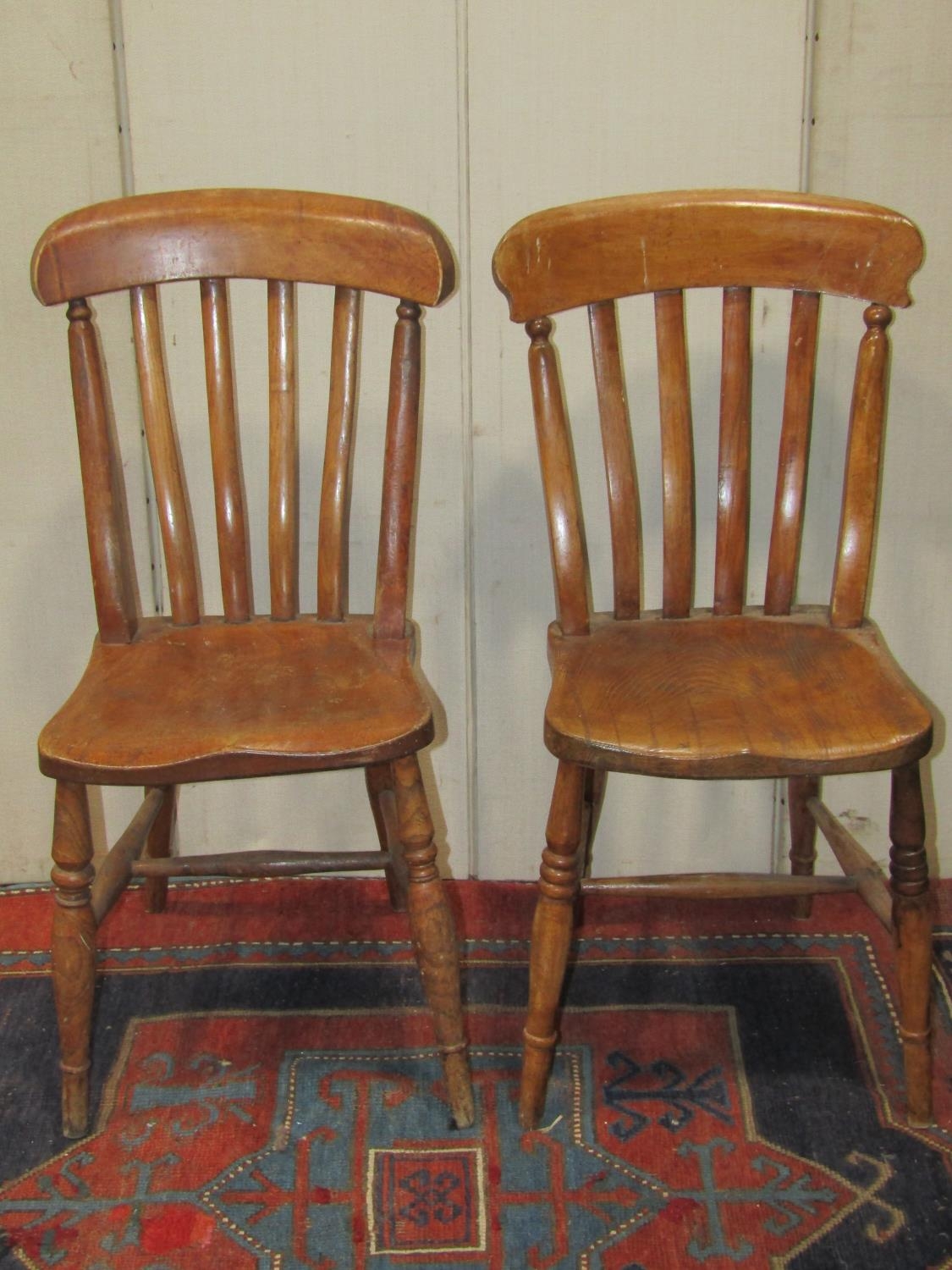 A harlequin set of eight Windsor elm and beechwood lathe back kitchen chairs raised on turned