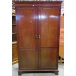 A Georgian style mahogany wardrobe with moulded cornice over a pair of full length panelled doors