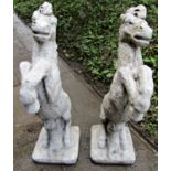 A pair of cast composition stone garden ornaments/pier caps in the form of rearing horses, 80 cm