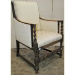 A 1920s armchair in the carolean style with upholstered drop in seat raised on spiral twist block