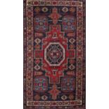 A small middle eastern design rug with predominantly red and blue geometric pattern, 133cm x 70cm