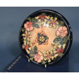 A Moorcroft plate with honeysuckle and dog rose border decoration and impressed and painted marks to