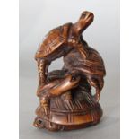 A carved hard wood netsuke in the form of four clambering tortoise