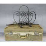 A vintage suitcase with a canvas protective cover, a wrought iron Canterbury, coal tongs and a
