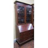 An inlaid Edwardian mahogany bureau bookcase, the bureau of three long drawers on swept supports,
