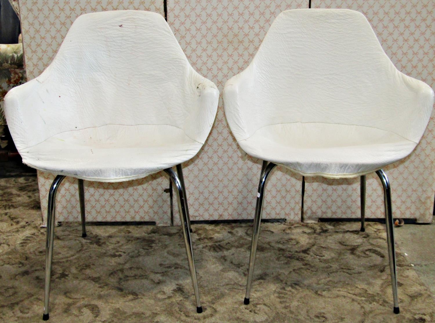 A set of four moulded plastic retro dining chairs with shaped outline raised on tubular supports,