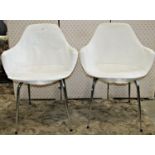 A set of four moulded plastic retro dining chairs with shaped outline raised on tubular supports,