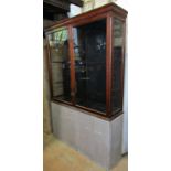 A vintage mahogany shop display cabinet with chamfered and moulded framework and enclosed by a