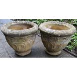 A pair of small weathered cast composition stone garden planters of circular tapered form with