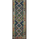 A Maimana Kelim runner with a central row of diamonds on a predominately green ground, 193cm x 63cm