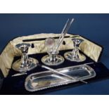 A presentation box of a pair of squat silver candle sticks and an inkwell, pen tray and three silver