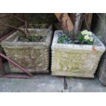 A set of three weathered cast composition stone square garden planters with floral and gadroon