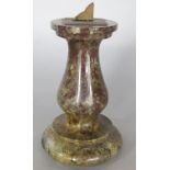 A miniature turned and polished serpentine pedestal sun dial supporting a brass dial, 11cm high